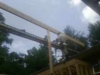 Carpenter setting a ridge beam over a new addition frame — Ice Dam Removal by Roofing Brothers in Oneonta