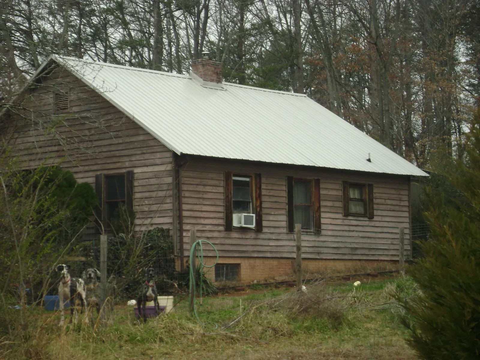 White metal roof on an old wood sided farmhouse, from a Metal Roof Installation job in Oneonta